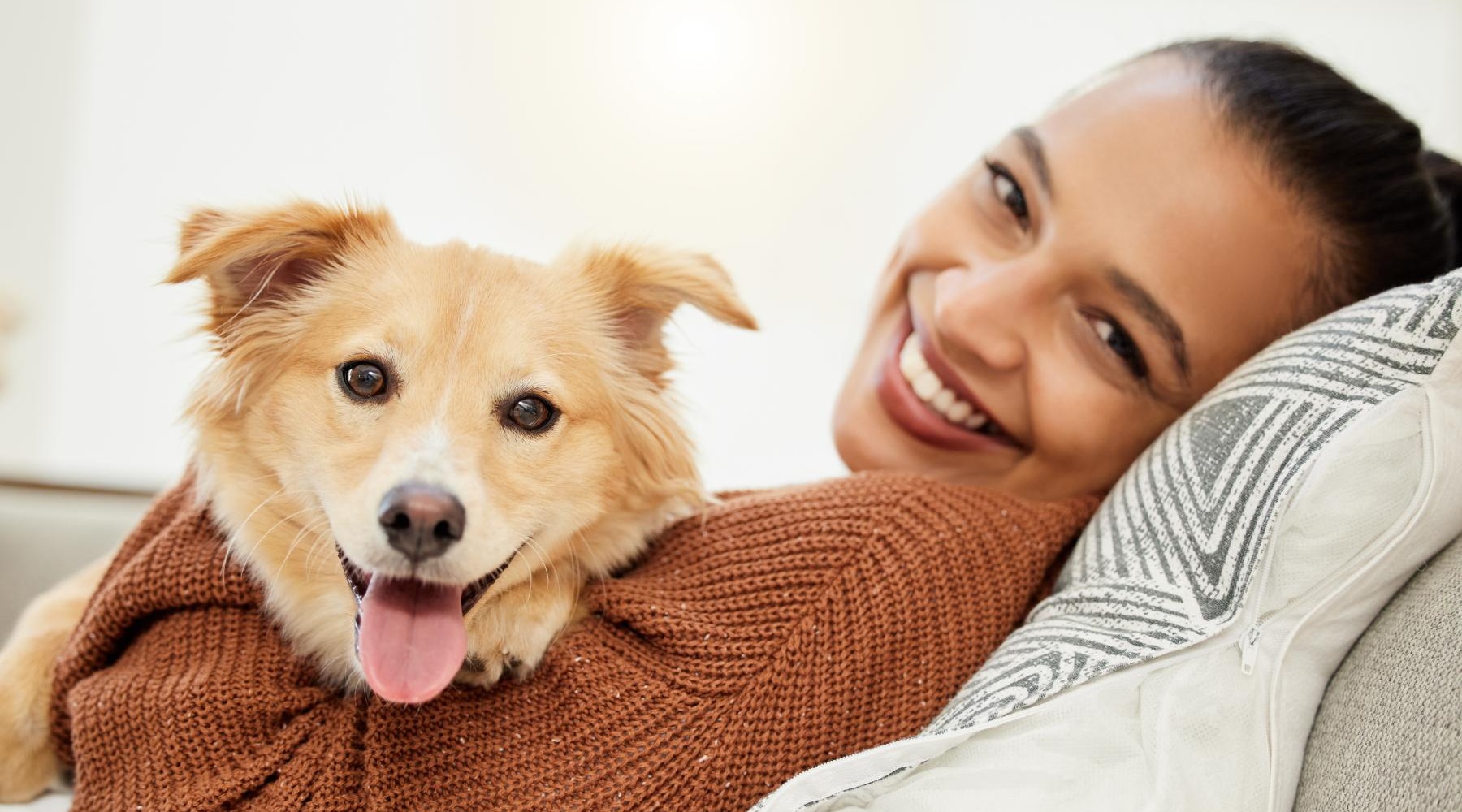 a person lying on a couch with a dog